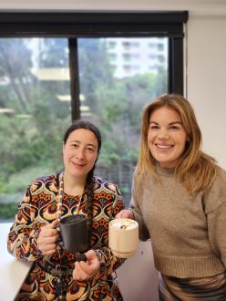 Noemi Artiste and Laura Simpson holding hot chocolates.