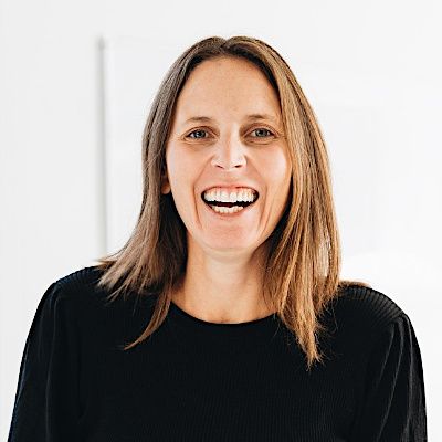 Trudi Uttinger smiling headshot. She has shoulder length brown hair and is wearing a black top.