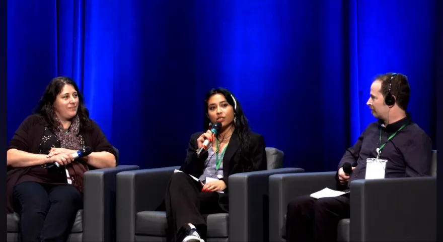 From left to right Marie Luce Aleisha and Brendan on stage for their panel. Aleisha is using the microphone to speak.