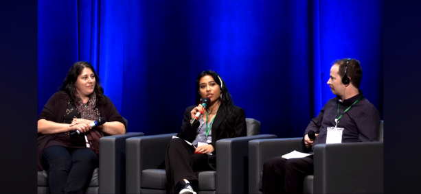 From left to right Marie Luce Aleisha and Brendan on stage for their panel. Aleisha is using the microphone to speak.