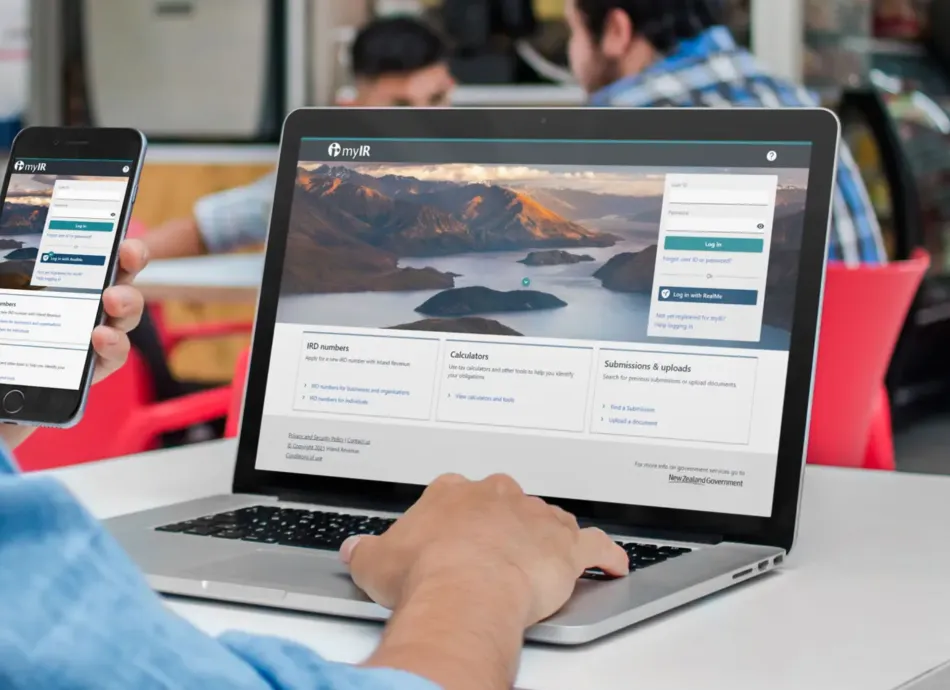 Person using a laptop and mobile device to navigate the home page of Inland Revenues website.