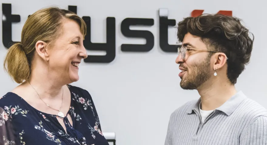 Two people smiling while talking about the content on a tablet device