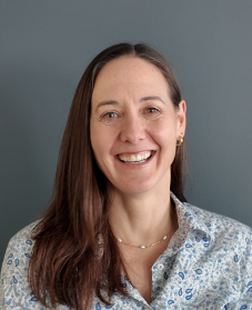 Smiling headshot of Sarah Ellison. She has long brown hair and wears a collared shirt