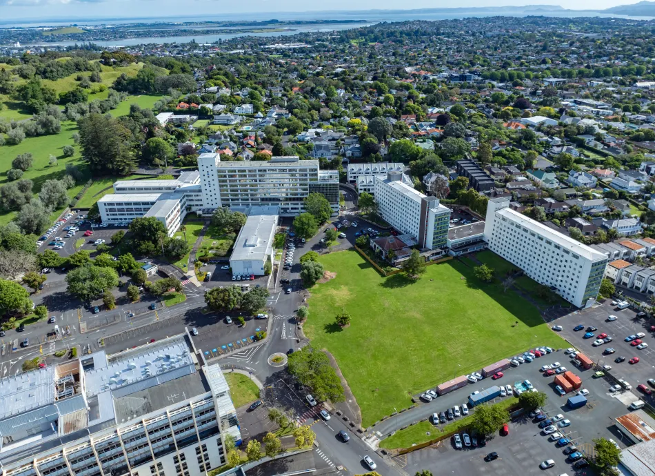 High-angle view of Auckland hospital complex, parking lots, and surrounding residential areas. Urban landscape with various buildings and green spaces. GREENLANE HOSPITAL, AUCKLAND, NEW ZEALAND