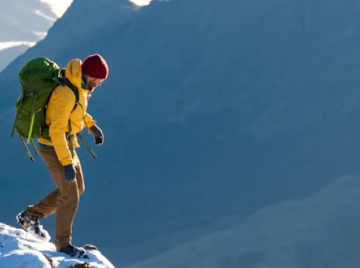 A man hiking on Mount Hikurangi in the snow with a view of the landscape