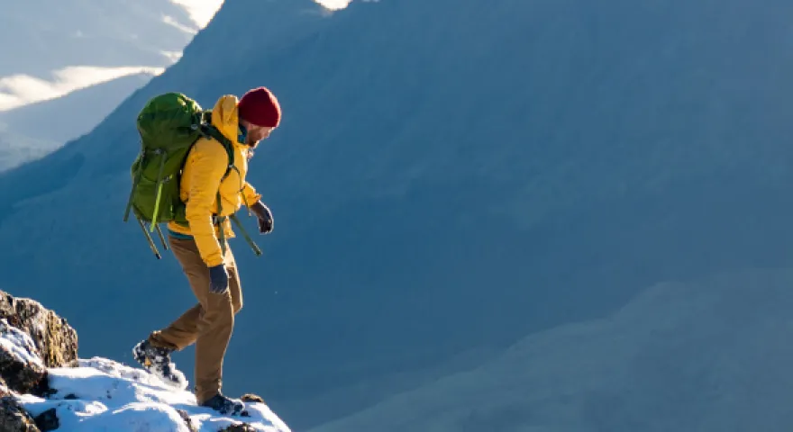 A man hiking on Mount Hikurangi in the snow with a view of the landscape